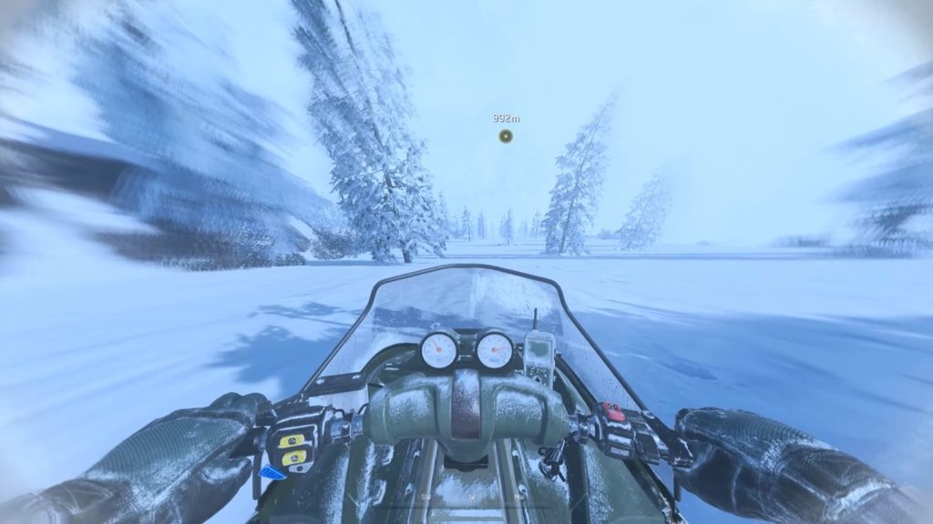Riding a snowmobile on full speen down the snowy hill