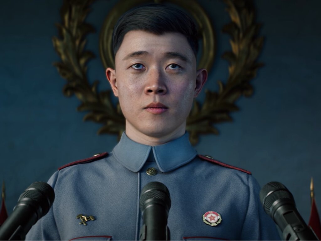 A Korean general stands in front of three mics to deliver a speech